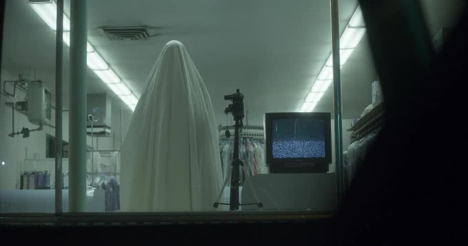 A person covered in a sheet with a camera and a television set next to them