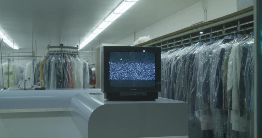 Vintage television plays static on the counter of a laundry