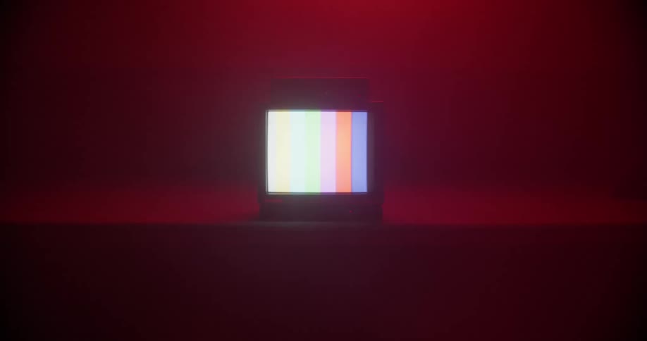 A television broadcasting a test pattern sits on a stage