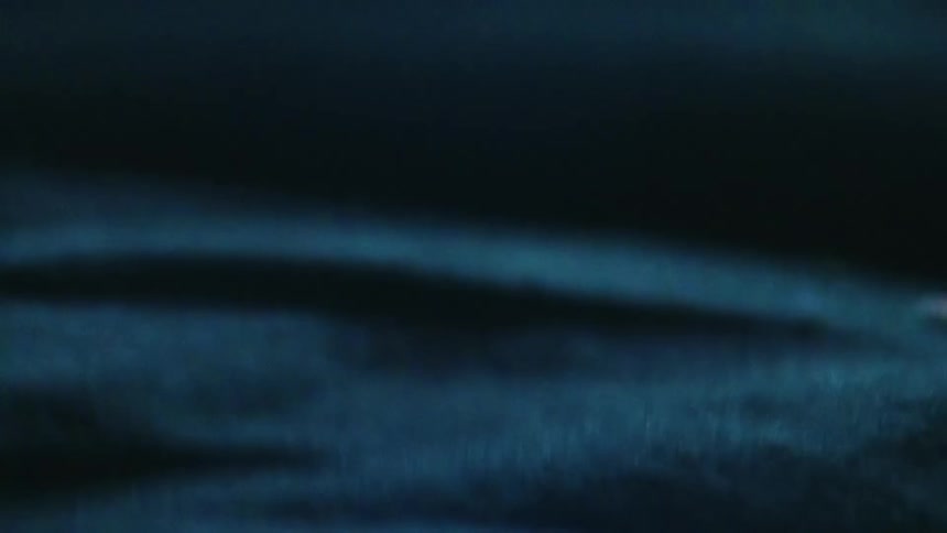 Close up of blue cloth canvas waving under a dim light