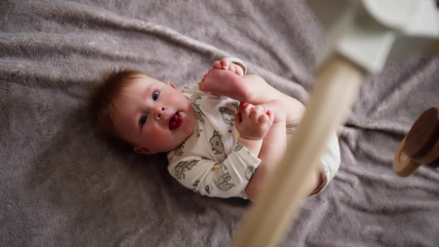 A baby is playing in the crib