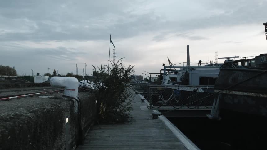 Boats tied up against a pier and bikes parked along it