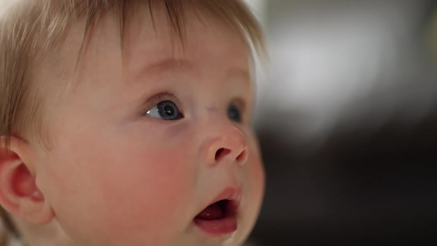 Blue eyed baby stares open mouthed