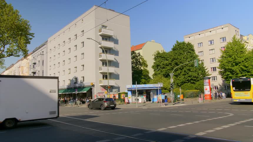 Vehicles and people travel past the intersection