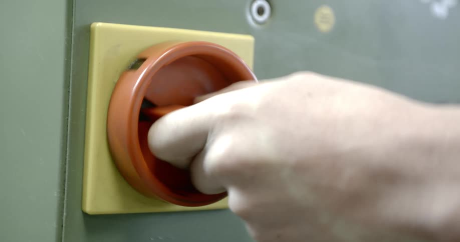 Hand reaches out and turns switch on door