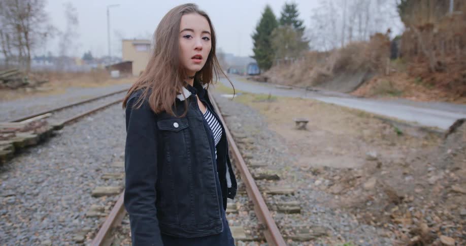 Young woman walking on the train tracks
