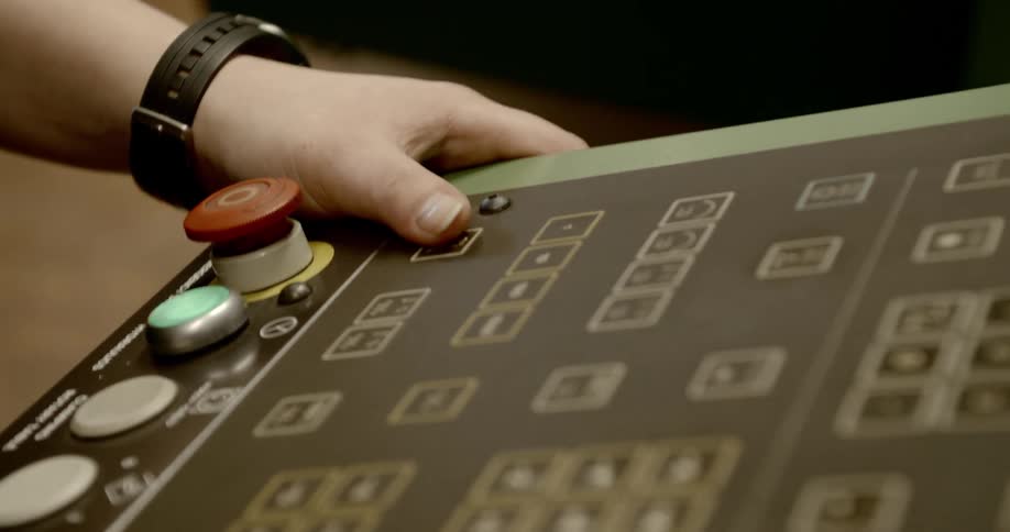 A person has his hand by a button on a machine