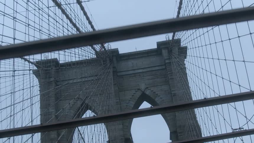 A flag sits atop the stone tower of a bridge