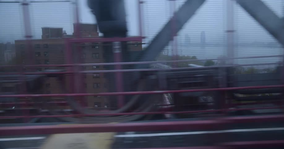 Fog covers river as bridge passes over highway bordered by low rise buildings