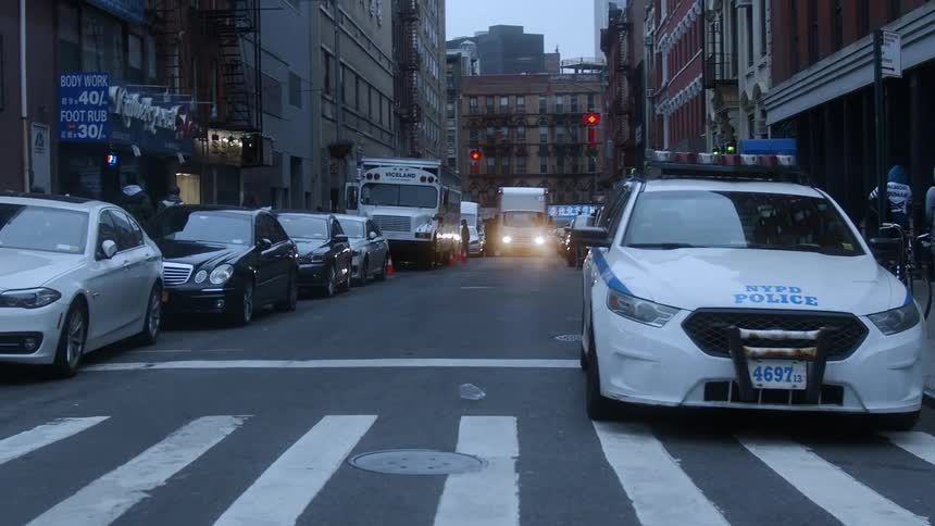 Cars parked on the sides of a street ni city downtown at sunset