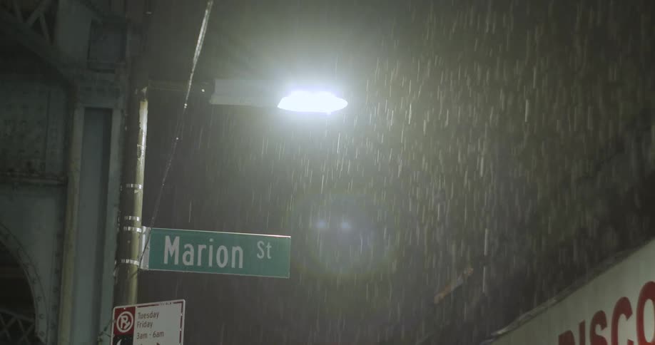 Rain falling on a small town street at night