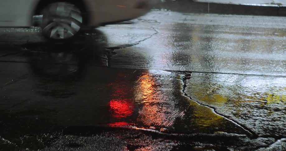 The car drives on the road on a rainy day