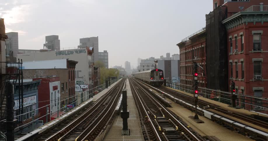 A passenger train departs the station and heads toward downtown