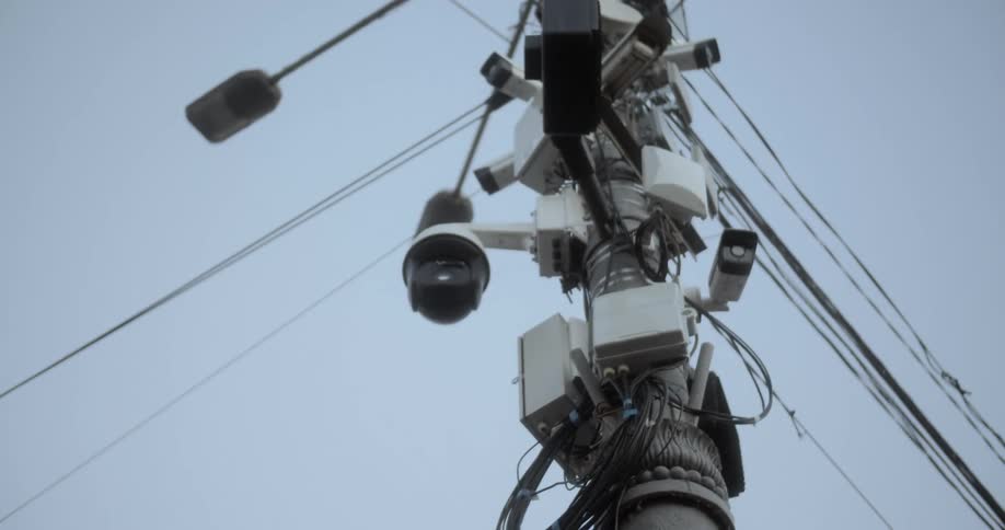 Utility pole filled with cameras and electric cables