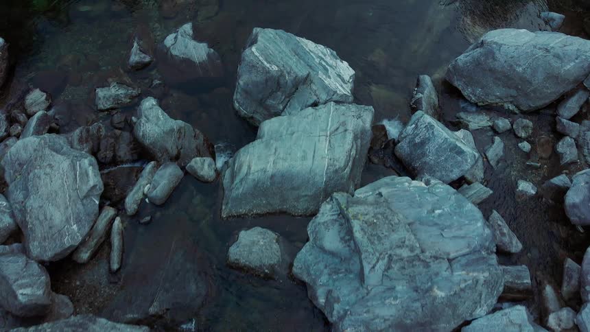 Aerial view of a river streaming through the rocks at evening