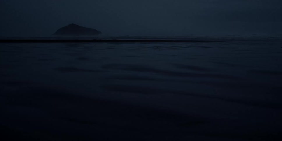 An island is visible on a dark night