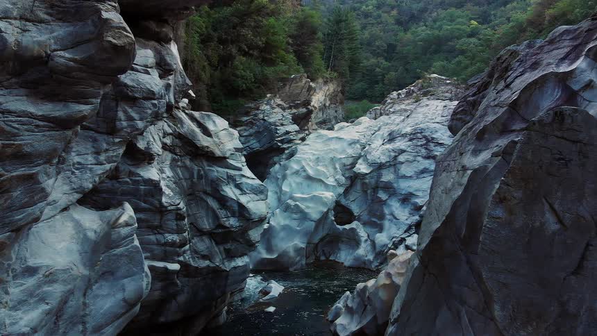 A river running at the bottom of a ravine of light blue stone