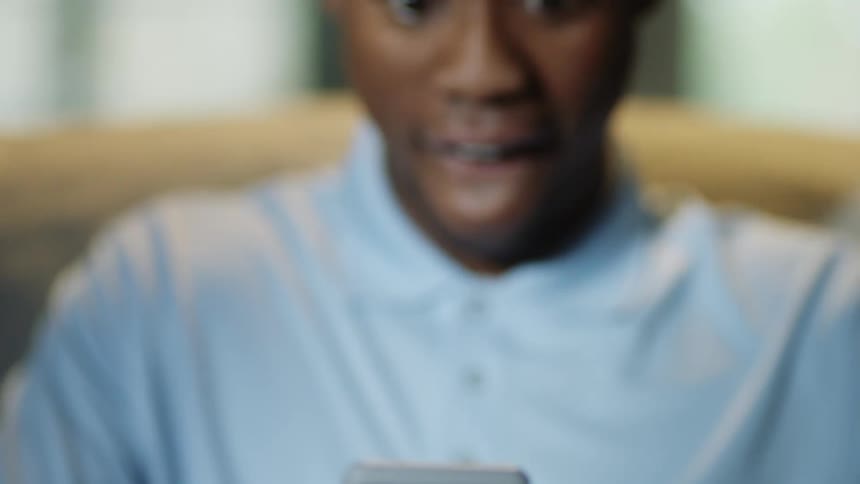 A man smiles looking at his phone