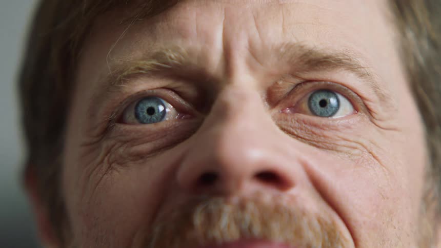 A man furrows his brow and then smiles