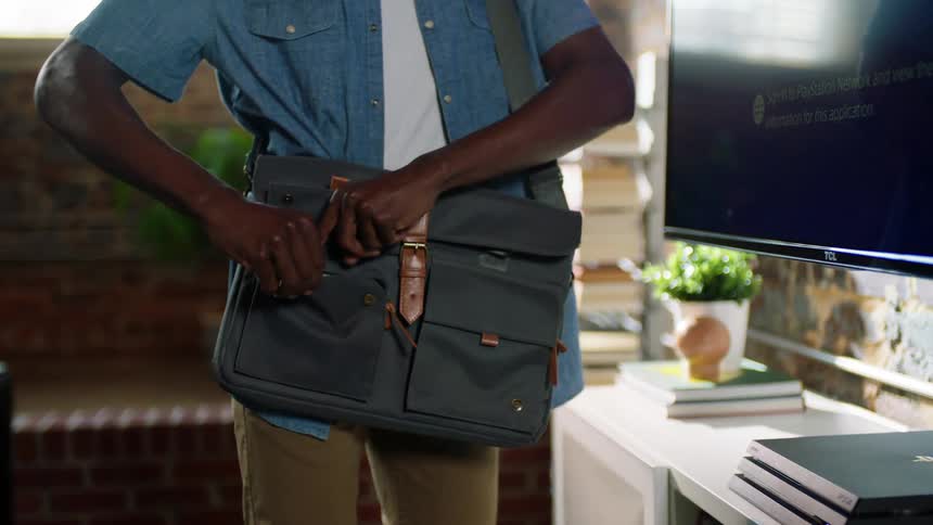 A man removes his phone from his bag and puts it down