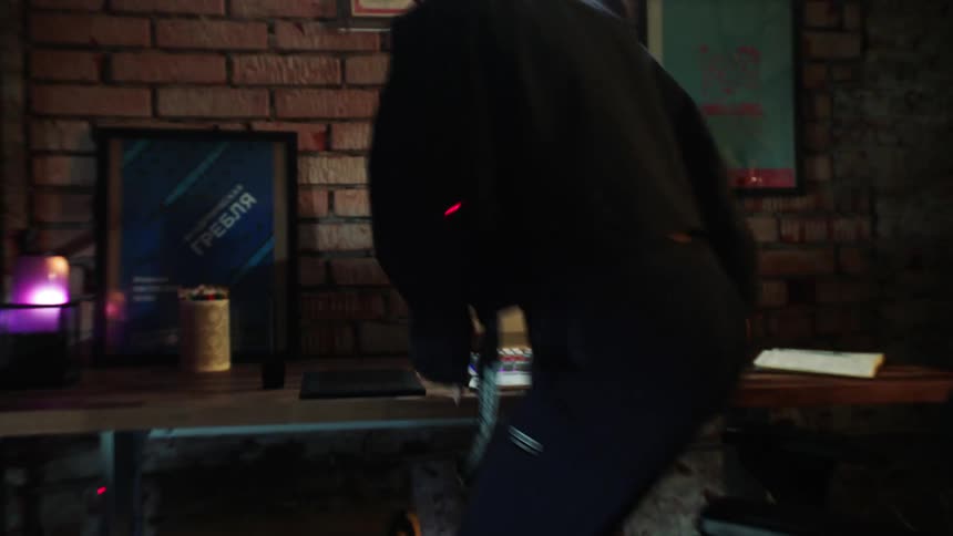 A person walks over to a computer desk and starts typing on the keyboard