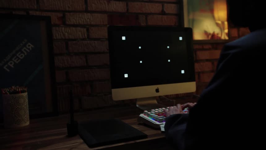 A person walking towards a computer sitting on a chair typing standing up and walking away