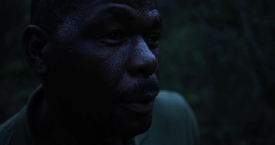 A man looks around cautiously while talking to someone