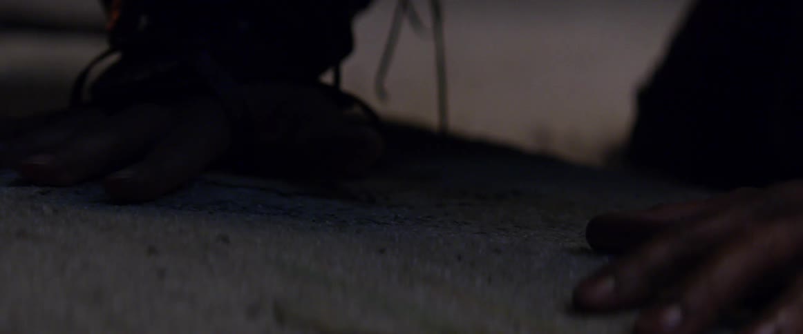 Hand with an electronic device attached slides across the sandy surface