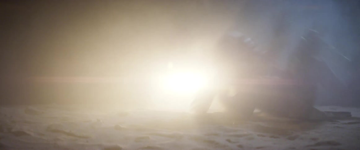 A man quickly rolls across the sand in a desert as a bright light shines
