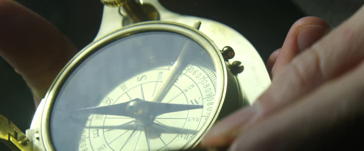 A man opens a cover on a compass