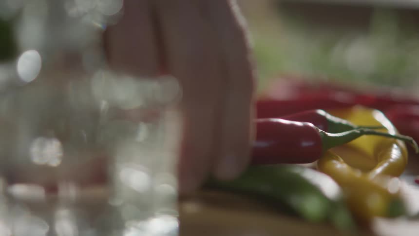 Person selects a pepper from among a small group of peppers of various colors