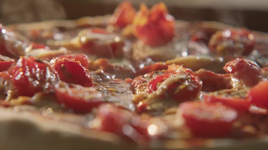 Steam rises from a freshly cooked pizza
