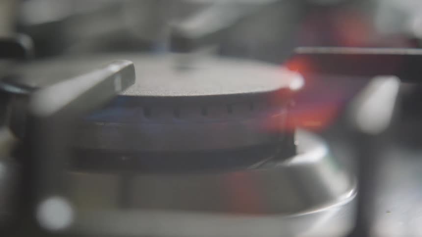 A flame igniting on a burner in a persons home