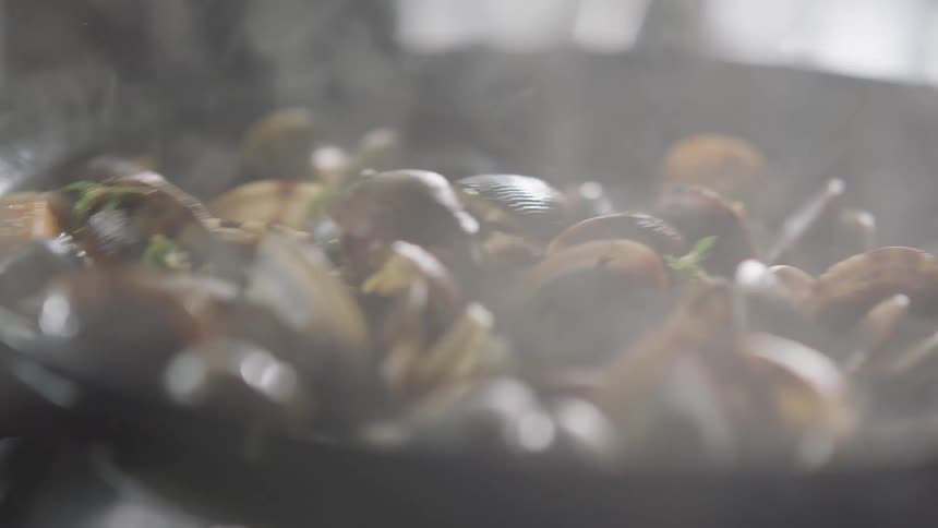 Food is tossed in a pan as it is sauteing