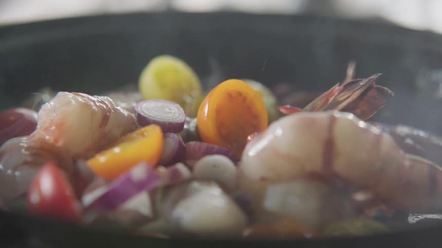 Steam rises from the cooking food