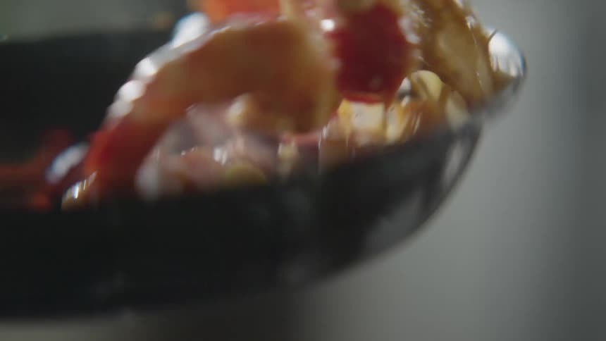 Food is being flipping around in the hot pan