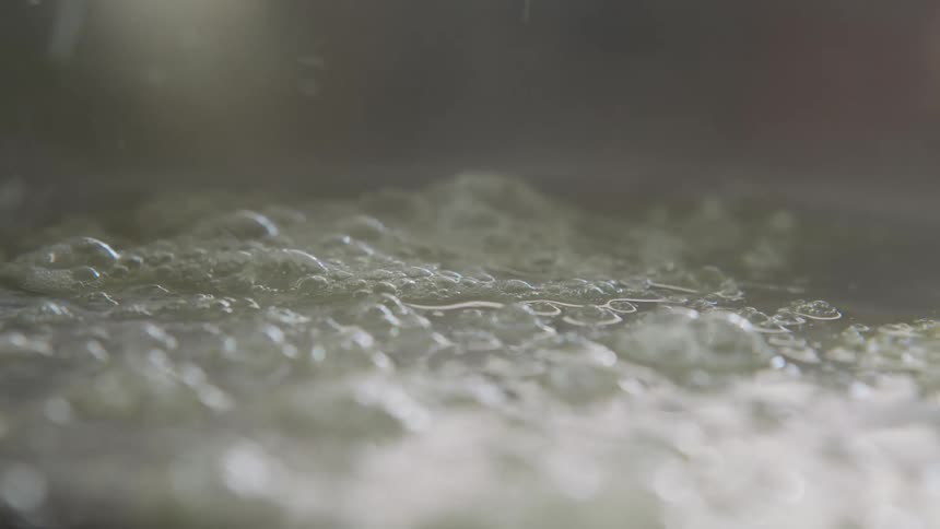 Clear bubbles form on surface of oil