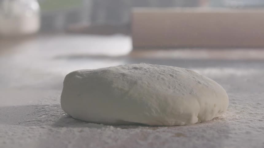 Dough drops onto a flour covered surface