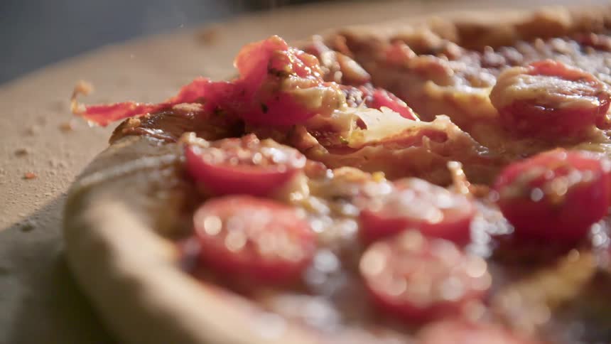 A person cutting a pizza