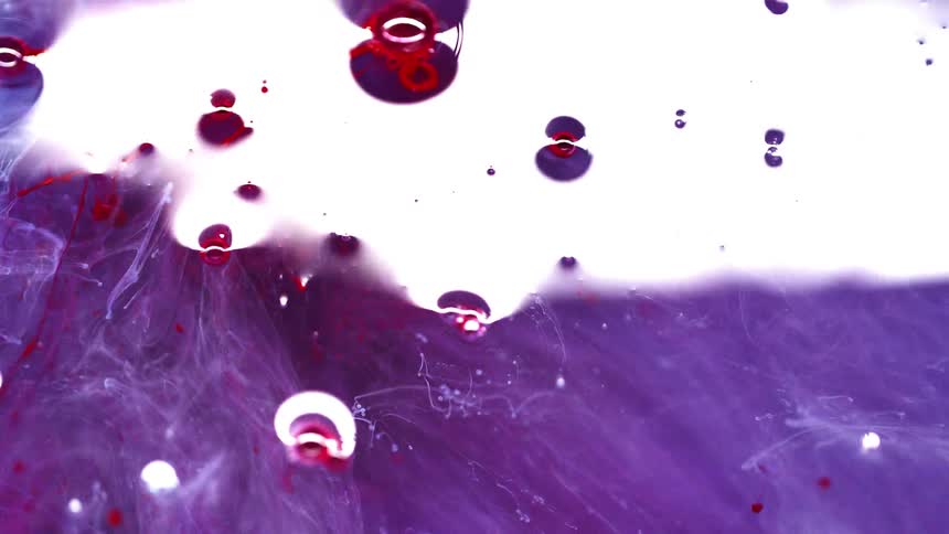 Light reflects lightly off mixture of red purple and white liquids