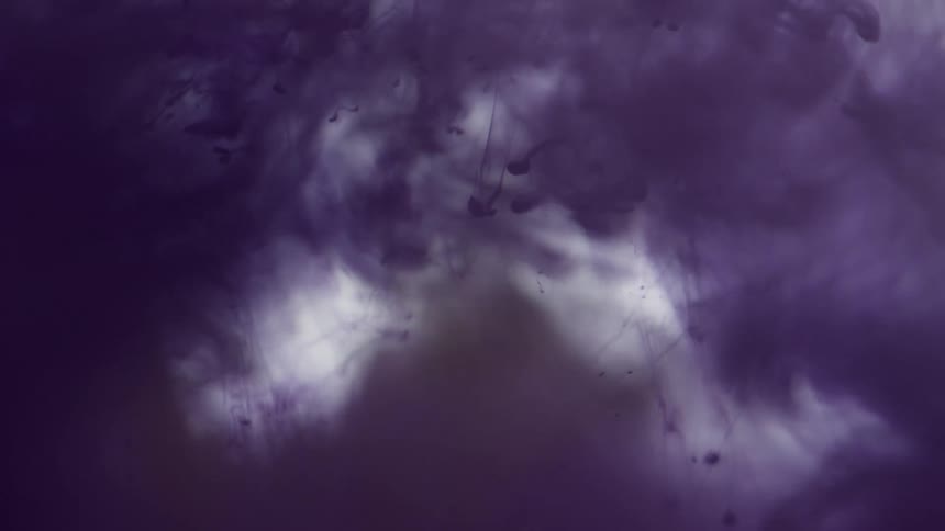 Purple ink flowing down a water tank against a white background