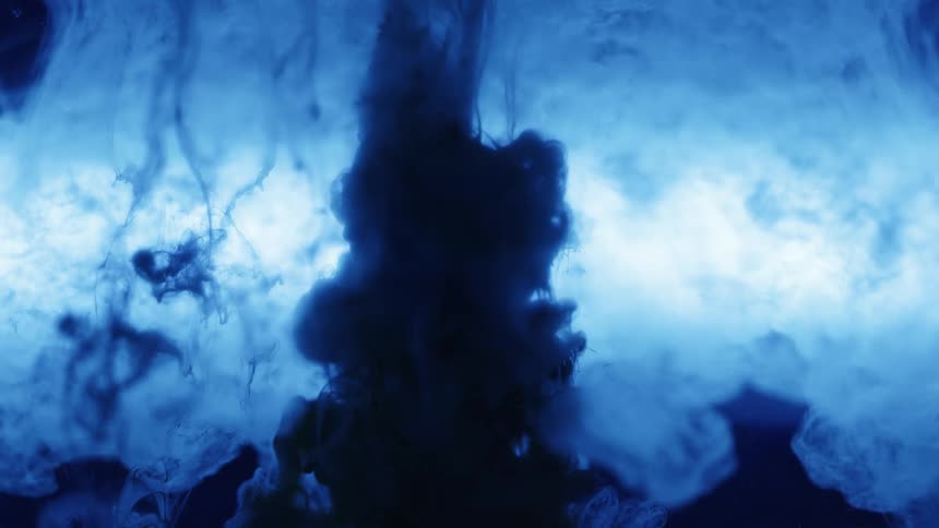 Blue ink flows over a sphere suspended in water inside a tank