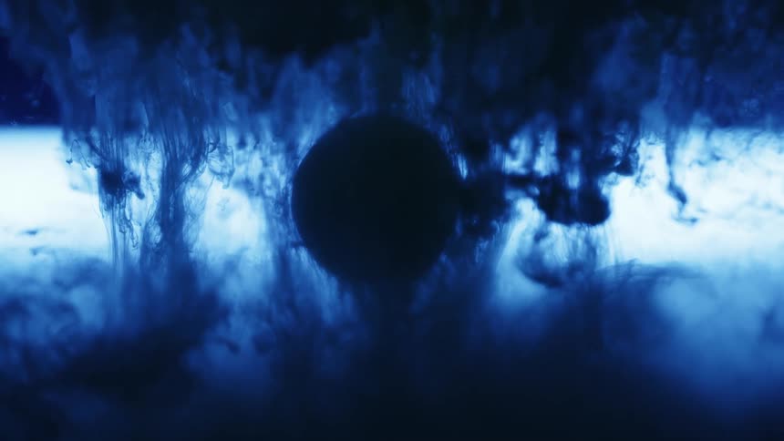 Blue inks runs around an orb in a solution