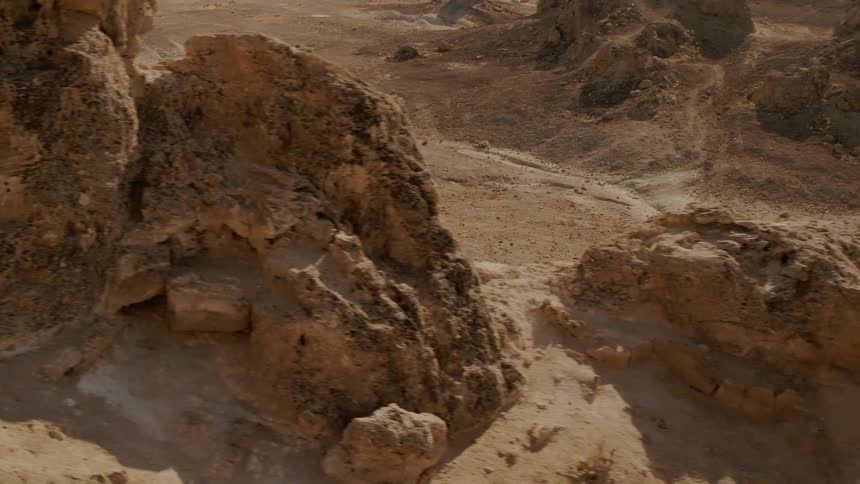 Bus drives on a dirt road through the desert