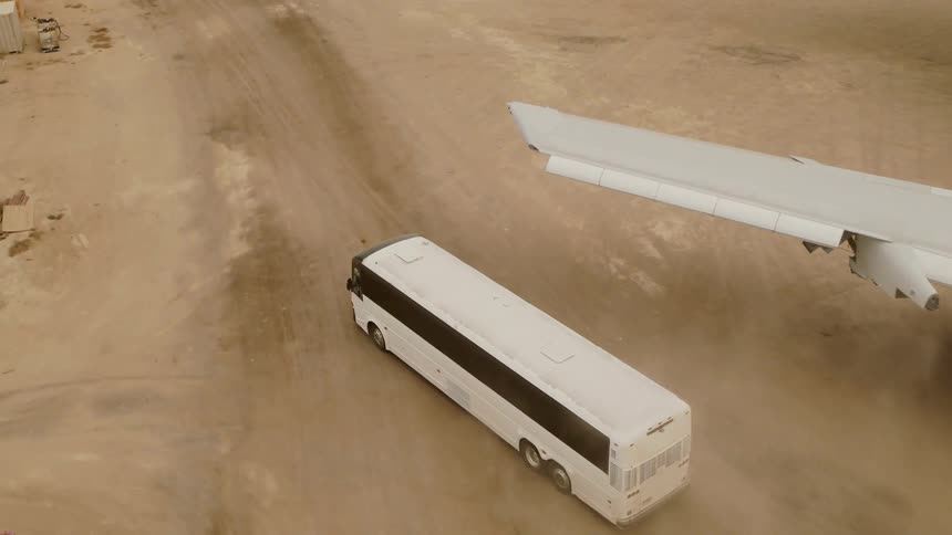 A bus drives away from the plane