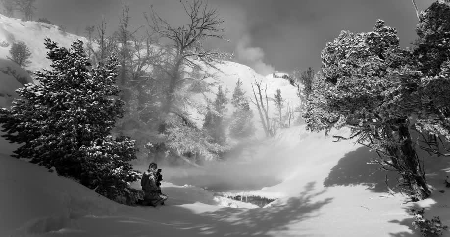 A person takes photos outside in the snow