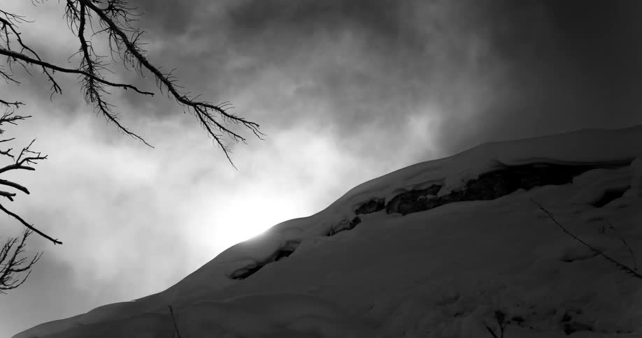 Clouds over a snow covered hill