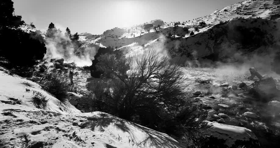 A man crosses the stream on the mountain
