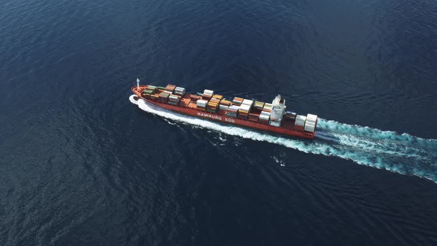 Aerial of freighter transporting cargo in the middle of the sea
