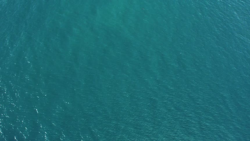 Top down aerial view of calm aquamarine ocean water